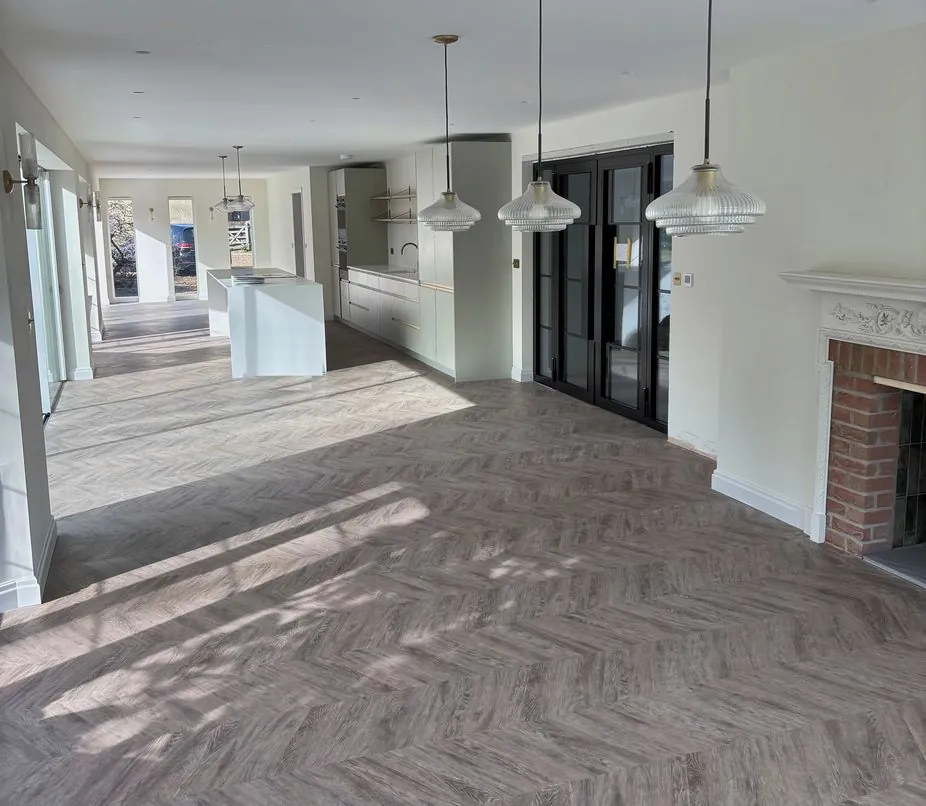 After: the opened-up living space with herringbone flooring and steel-framed glazed doors