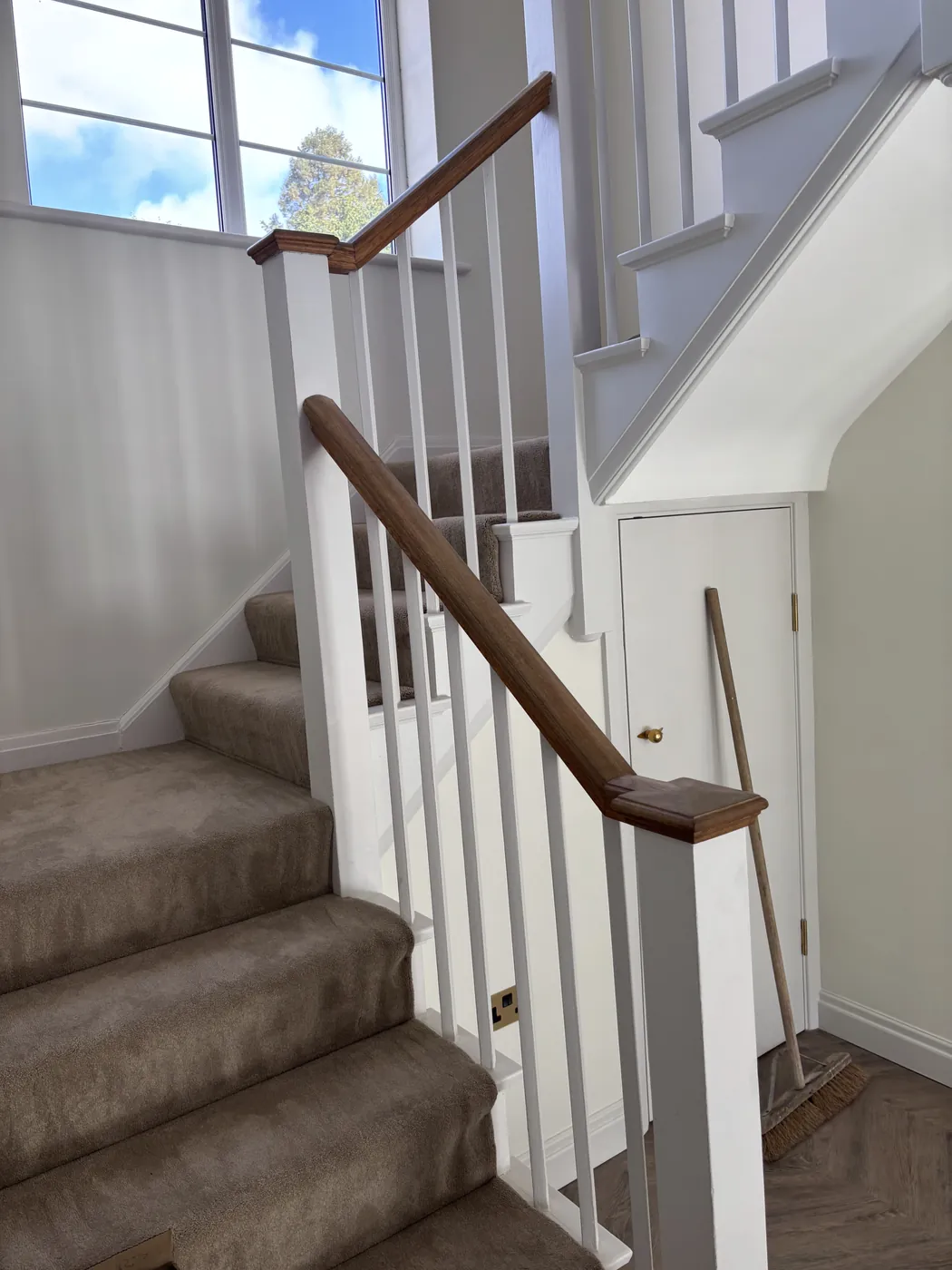 Refurbished staircase with a painted balustrade and timber handrail