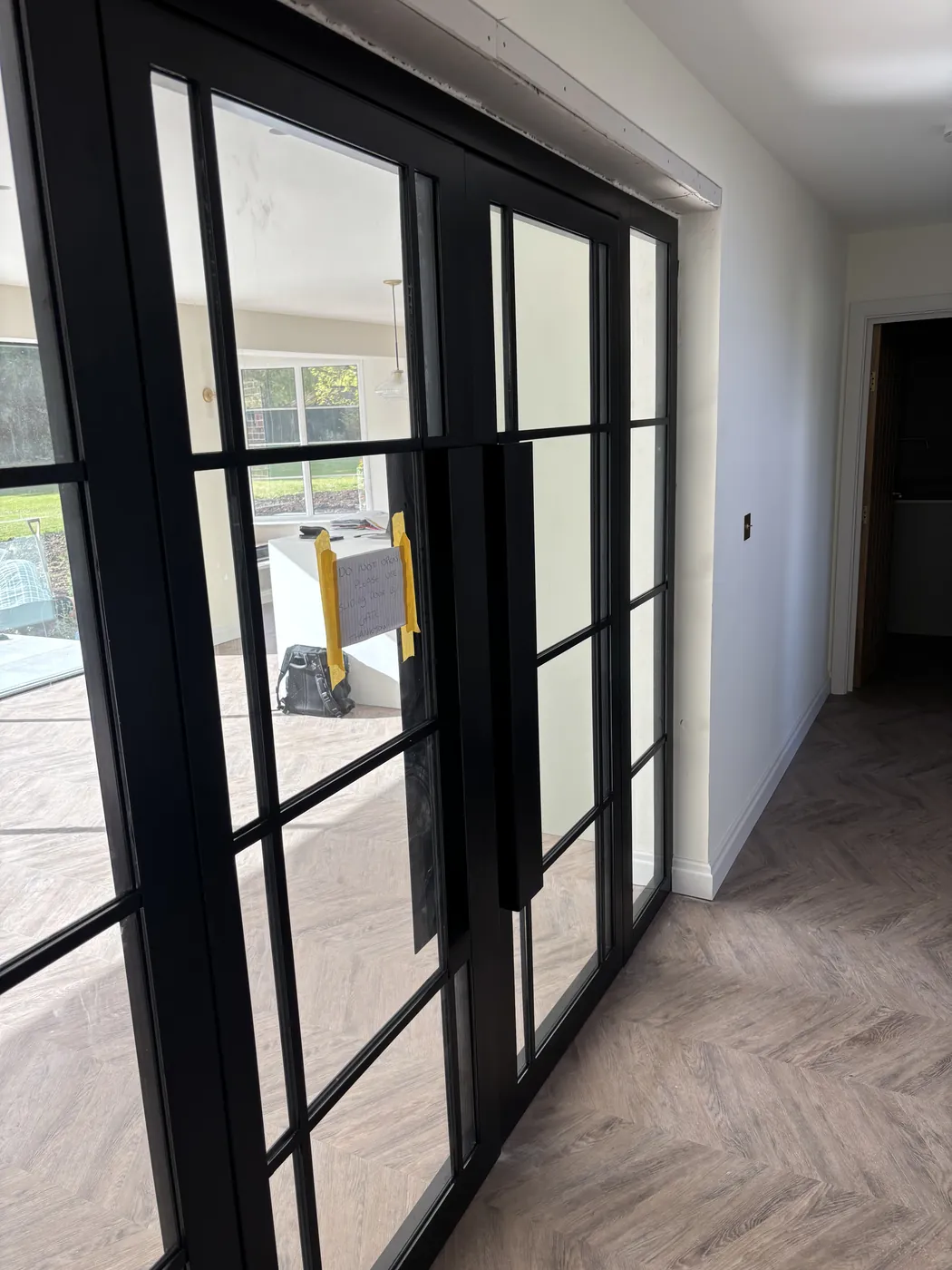 Steel-framed glazed doors between the living spaces, over herringbone flooring
