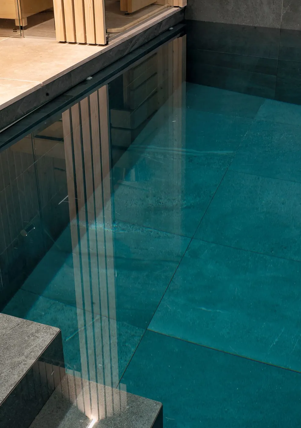 Looking down into the indoor pool, with oak cladding reflected in the water