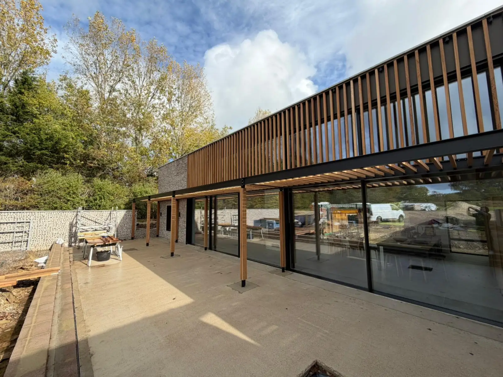 Terrace under the timber colonnade, with full-height glazing along the length of the house